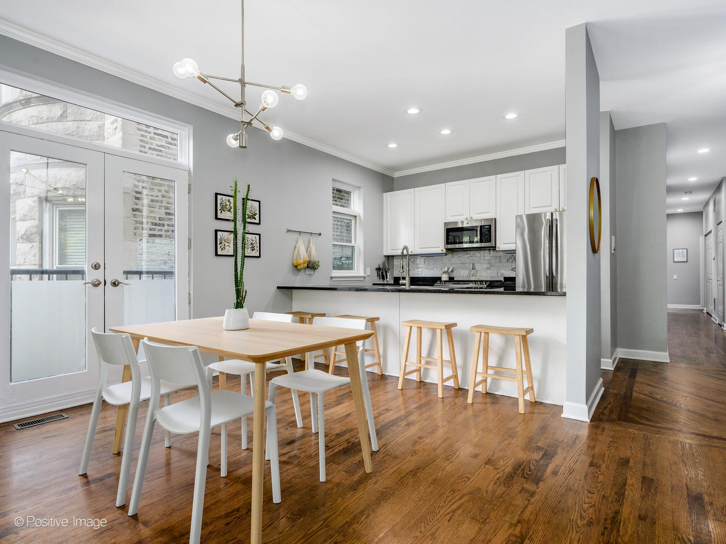 4315 North Kenmore Avenue, Unit 1N Chicago, IL 60613 - Photo 9 of 27 a view of kitchen with refrigerator a microwave oven a stove and a dining table with wooden floor