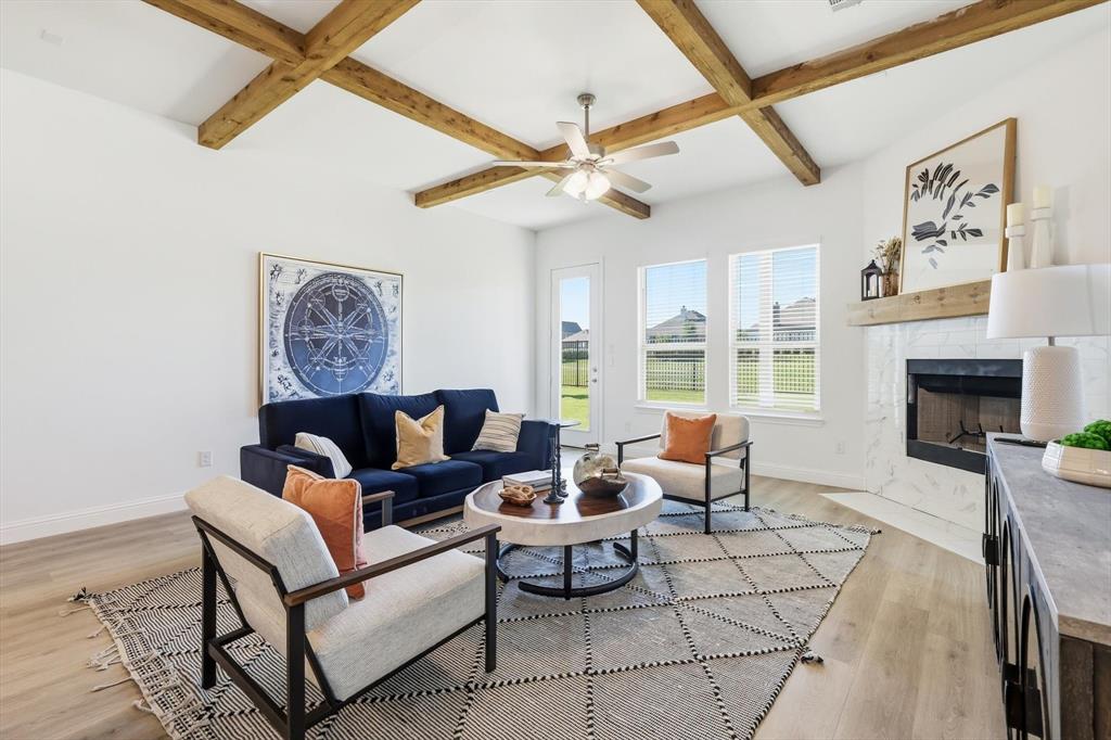 4017 Eagles Bluff Road Midlothian, TX 76065 - Photo 23 of 38 Spacious living area featuring exposed ceiling beams, a tile-surround fireplace with a wood mantel, and wood-finish flooring