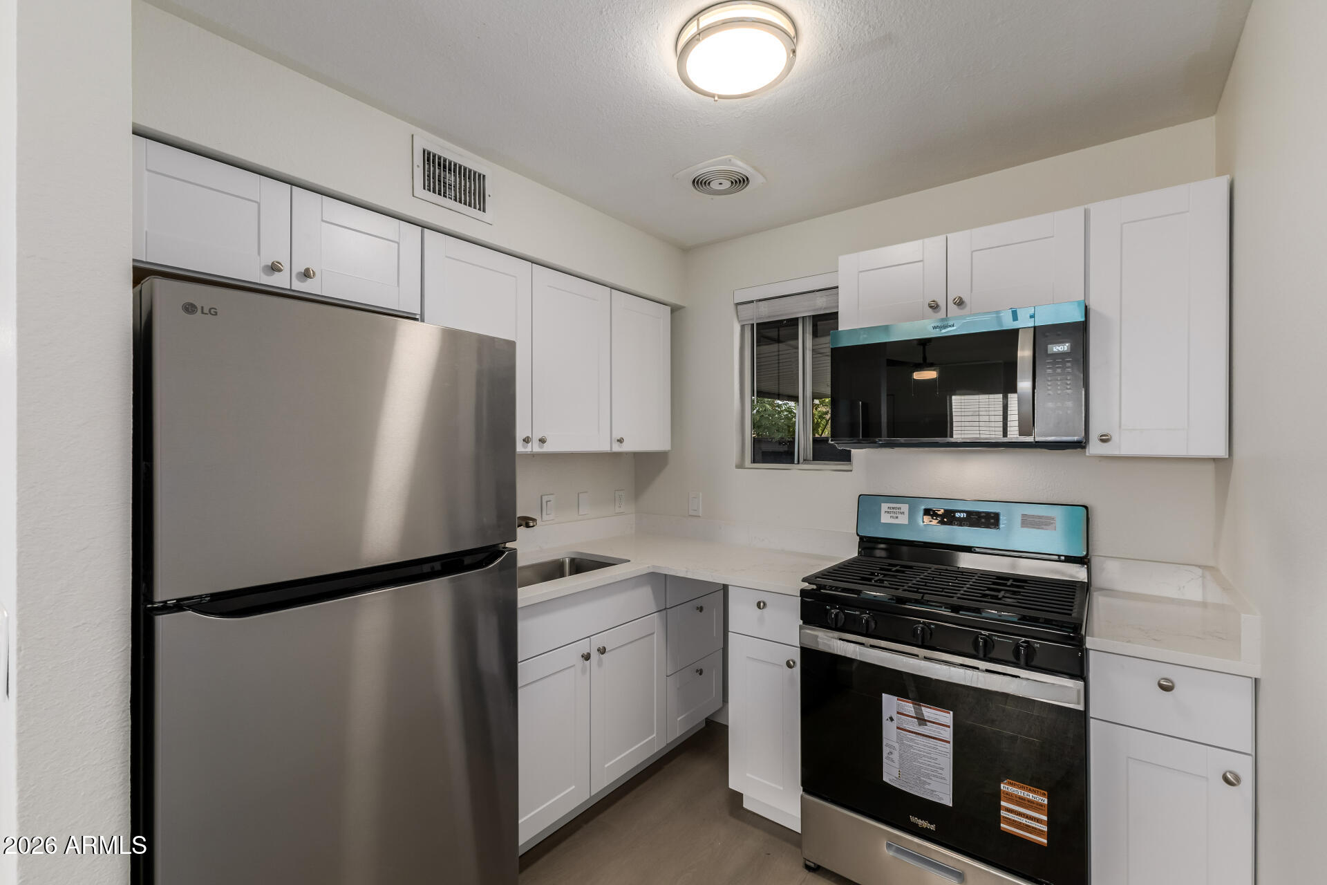936 West Rio Salado Parkway, Unit 4 Mesa, AZ 85201 - Photo 6 of 20 a kitchen with stainless steel appliances a refrigerator sink and microwave