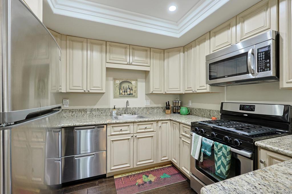 1415 1st Street Coronado, CA 92118 - Photo 13 of 36 a kitchen with stainless steel appliances granite countertop a stove microwave and sink
