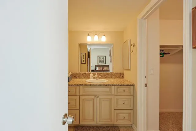 a bathroom with a granite countertop sink a mirror and a vanity