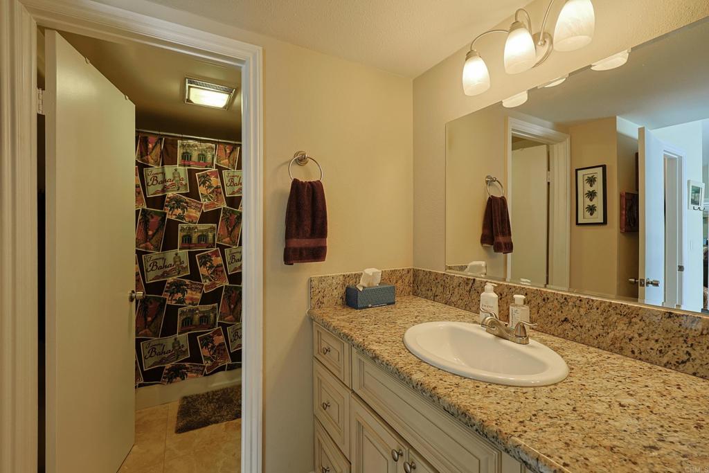 1415 1st Street Coronado, CA 92118 - Photo 27 of 36 a bathroom with a granite countertop sink and a mirror