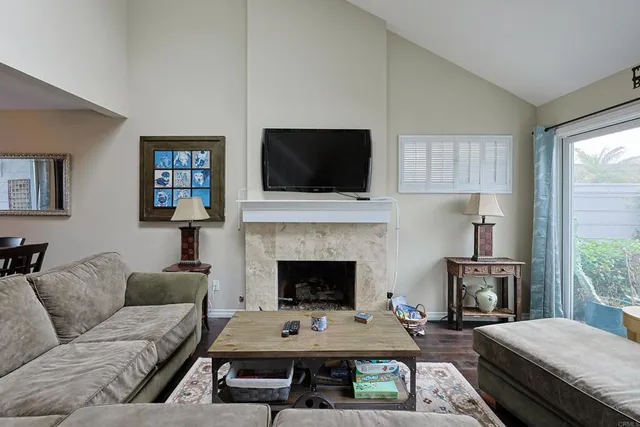 a living room with furniture a flat screen tv and a fireplace