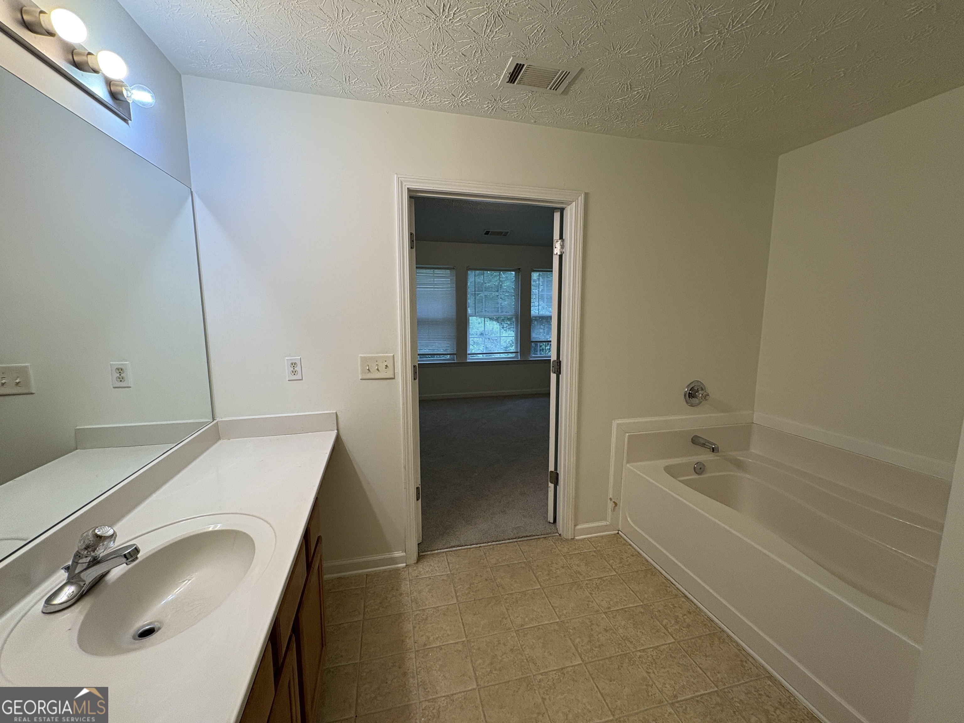 2485 Emma Way Northwest, Unit 2485 Lawrenceville, GA 30044 - Photo 11 of 20 a bathroom with a tub sink and mirror