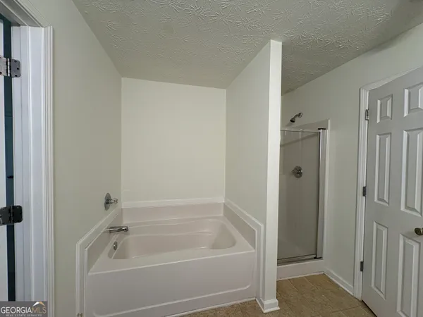 a bathroom with a tub shower vanity and a sink