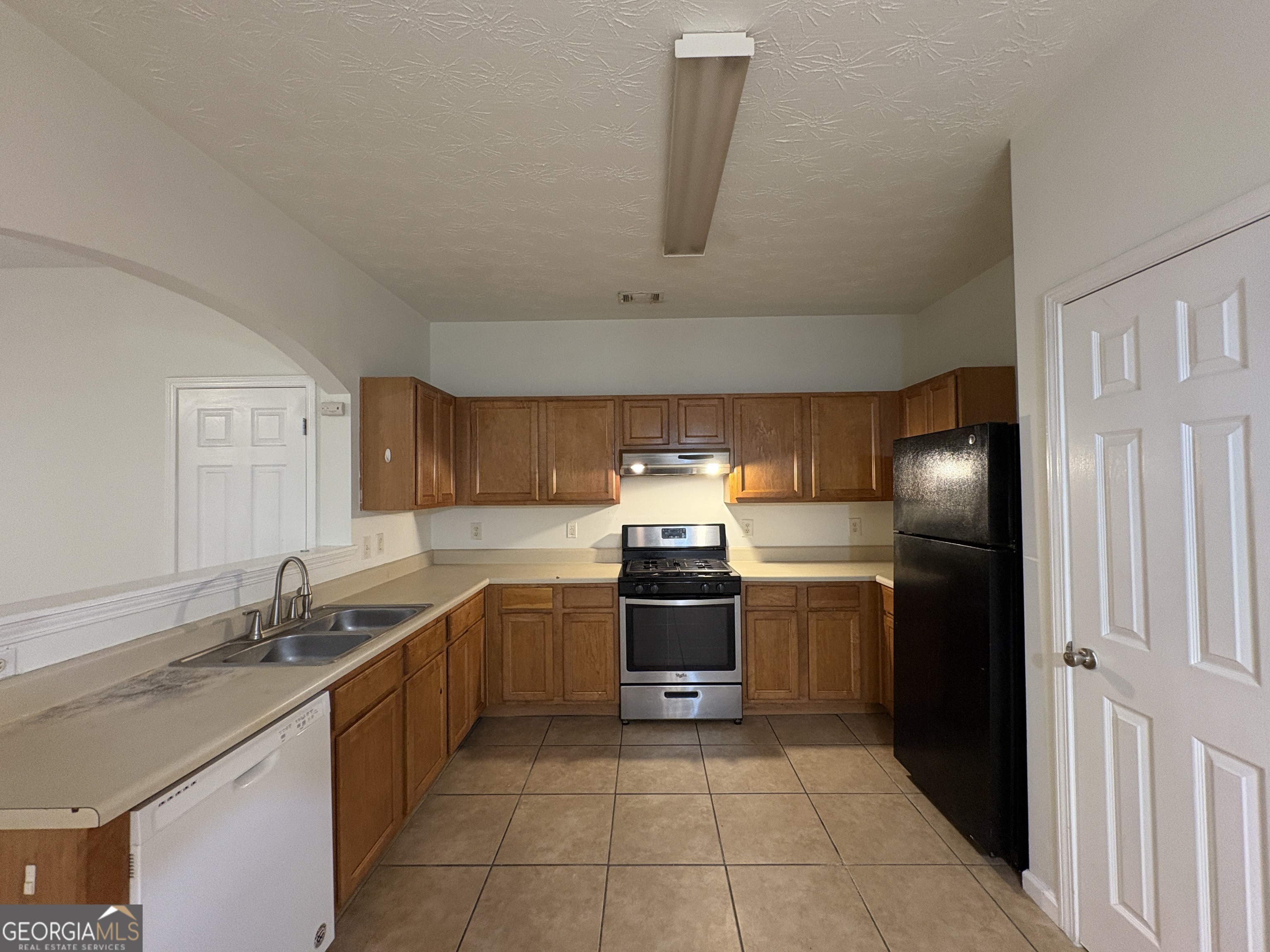 2485 Emma Way Northwest, Unit 2485 Lawrenceville, GA 30044 - Photo 4 of 20 a kitchen with stainless steel appliances granite countertop a sink stove and refrigerator