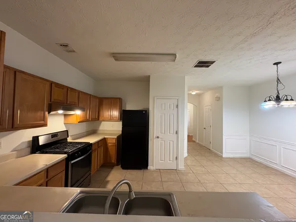 a kitchen with stainless steel appliances kitchen island granite countertop a sink and a refrigerator