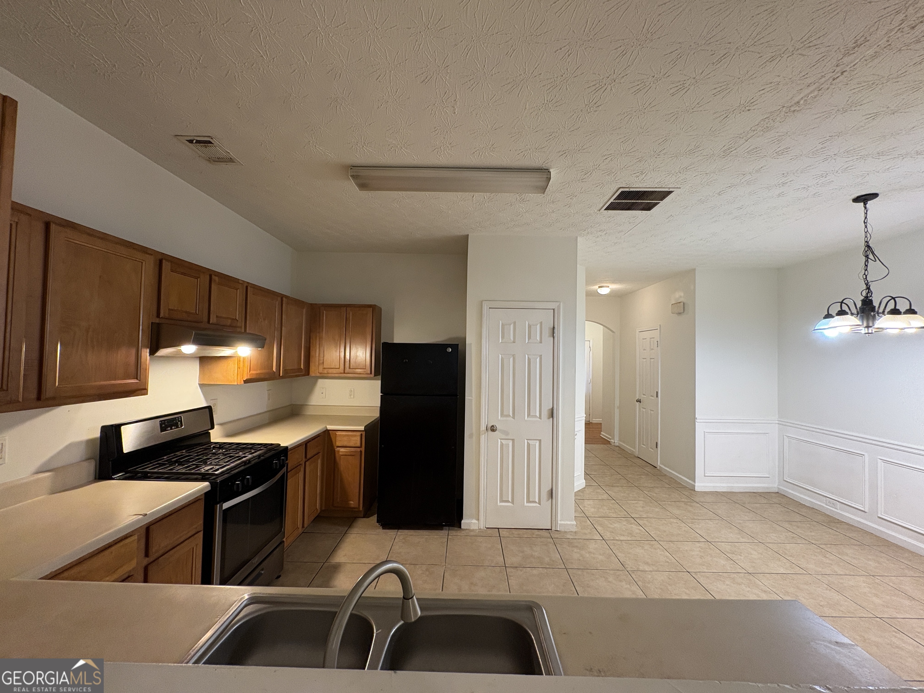 2485 Emma Way Northwest, Unit 2485 Lawrenceville, GA 30044 - Photo 5 of 20 a kitchen with stainless steel appliances kitchen island granite countertop a sink and a refrigerator