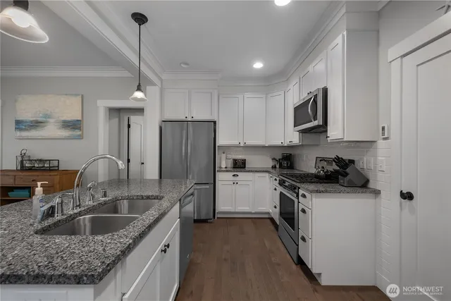 a kitchen with stainless steel appliances granite countertop a sink stove and refrigerator