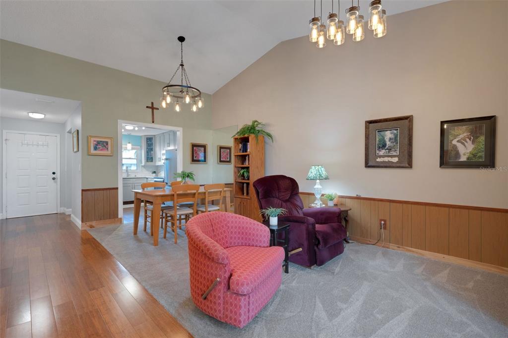 1065 Tartan Drive, Unit C Palm Harbor, FL 34684 - Photo 14 of 91 a living room with furniture a chandelier and a dining room