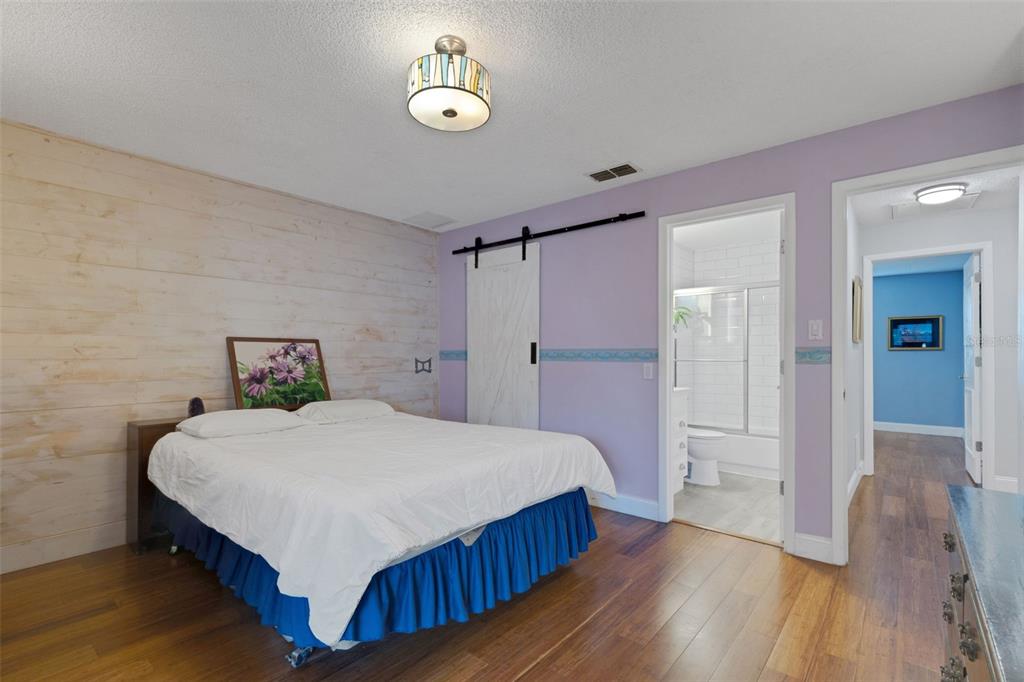 1065 Tartan Drive, Unit C Palm Harbor, FL 34684 - Photo 27 of 91 a bedroom with a bed and wooden floor