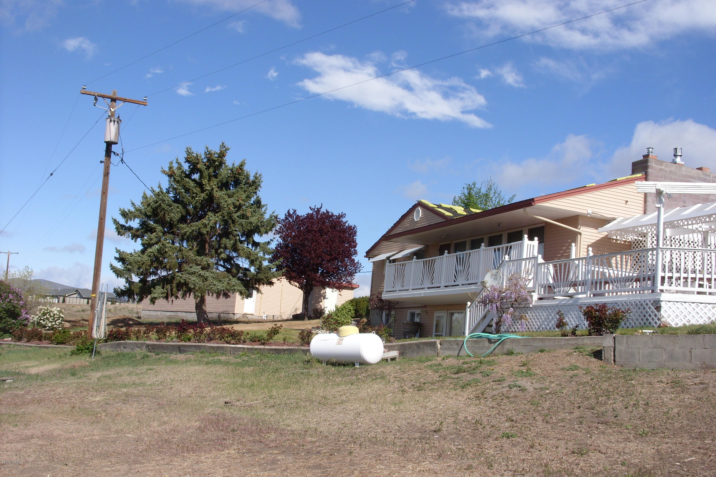 710 South Friedline Road Yakima, WA 98908 - Photo 3 of 22 a view of a white house with a yard and a garage