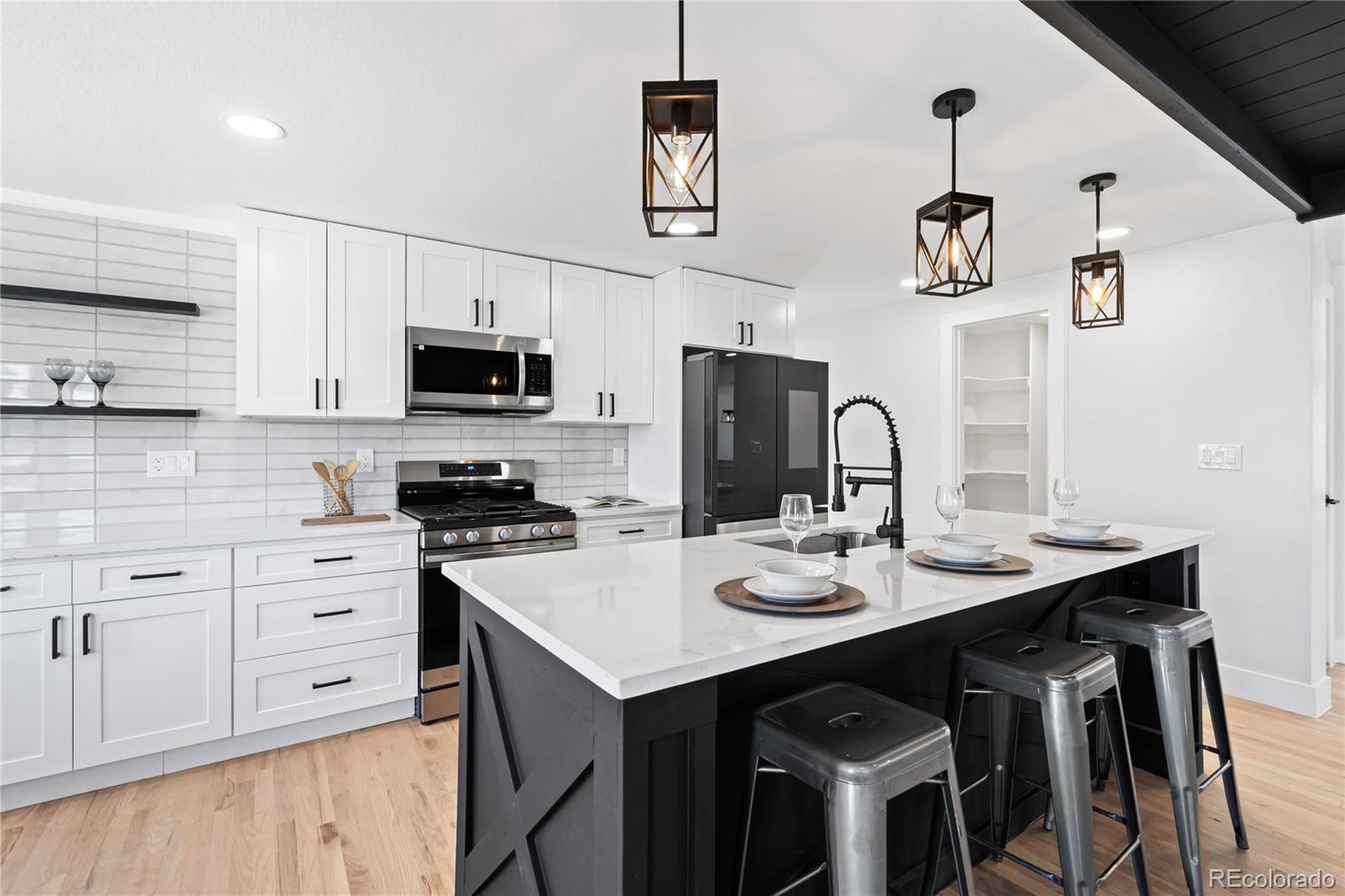6766 Zenobia Loop Westminster, CO 80030 - Photo 11 of 50 a kitchen with stainless steel appliances cabinets a sink and a stove