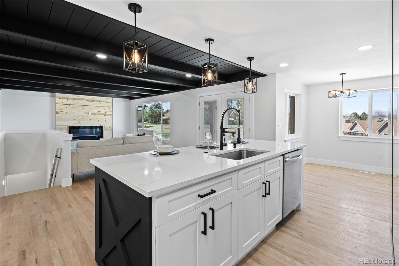 6766 Zenobia Loop Westminster, CO 80030 - Photo 16 of 50 a kitchen with stainless steel appliances granite countertop a sink stove and wooden floor