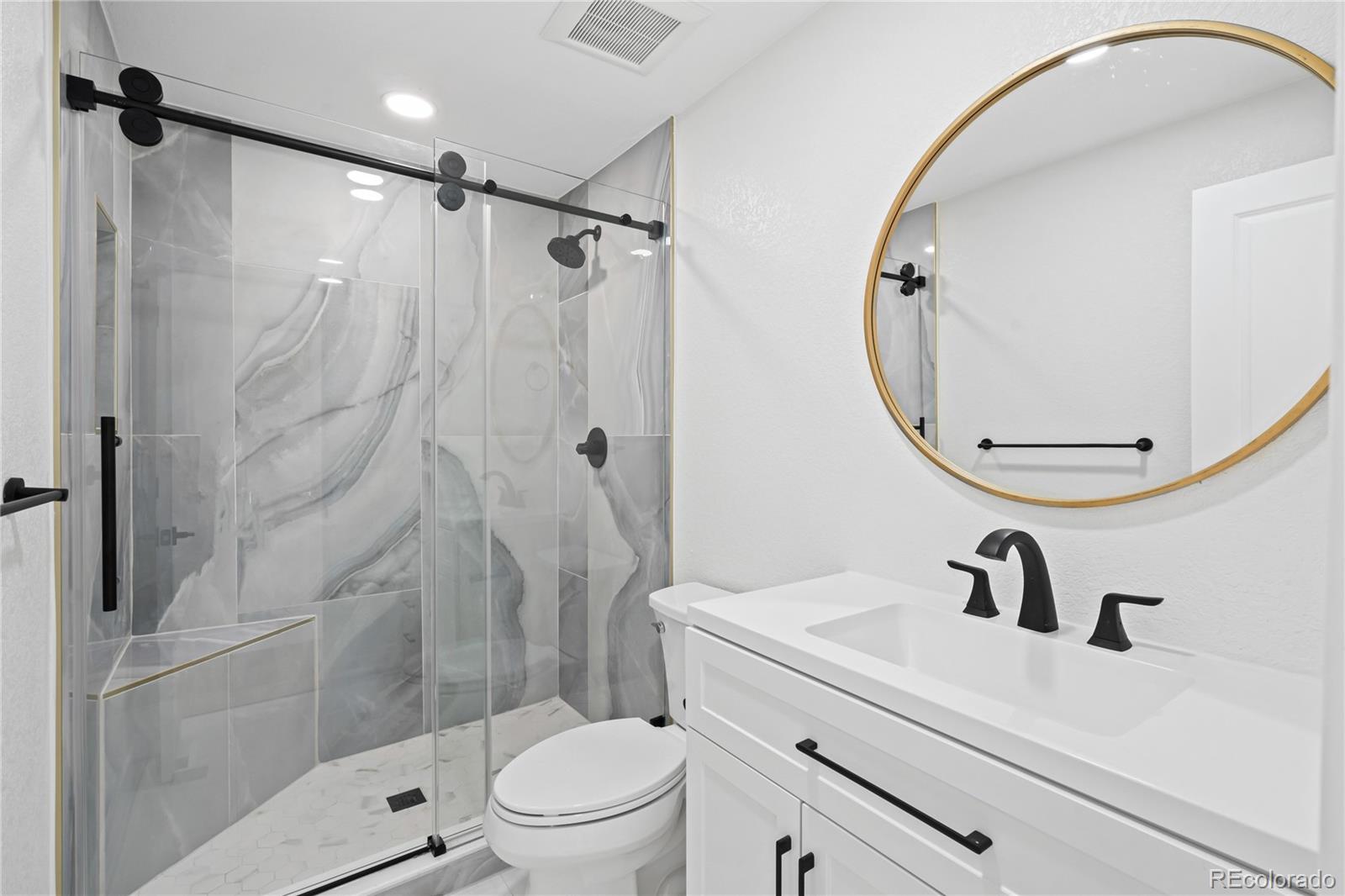 6766 Zenobia Loop Westminster, CO 80030 - Photo 19 of 50 a bathroom with a sink toilet and shower