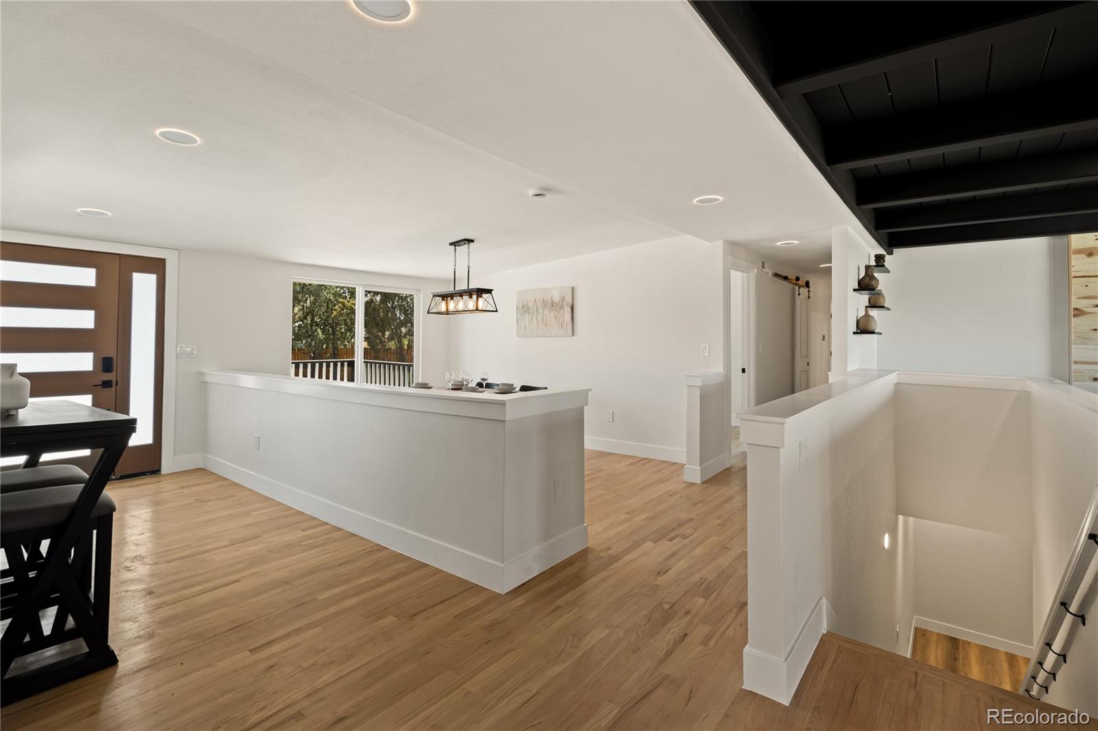 6766 Zenobia Loop Westminster, CO 80030 - Photo 23 of 50 a living room with wooden floors and kitchen view