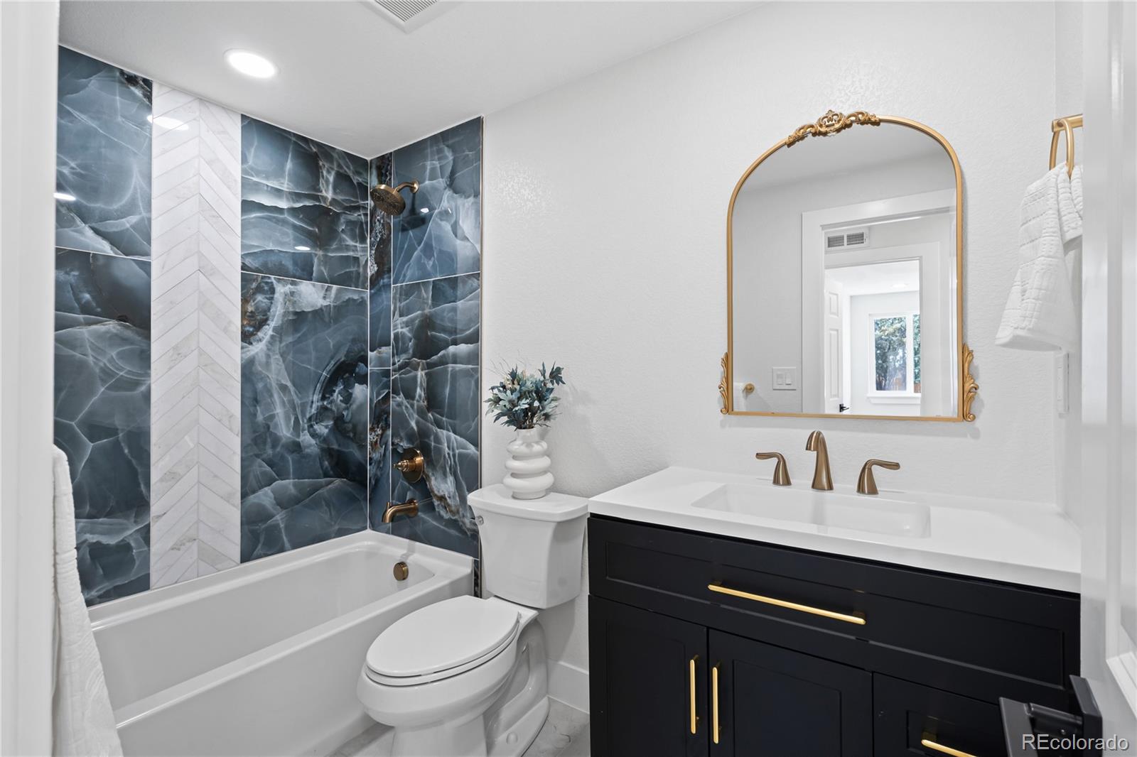 6766 Zenobia Loop Westminster, CO 80030 - Photo 26 of 50 a bathroom with a sink a toilet and shower