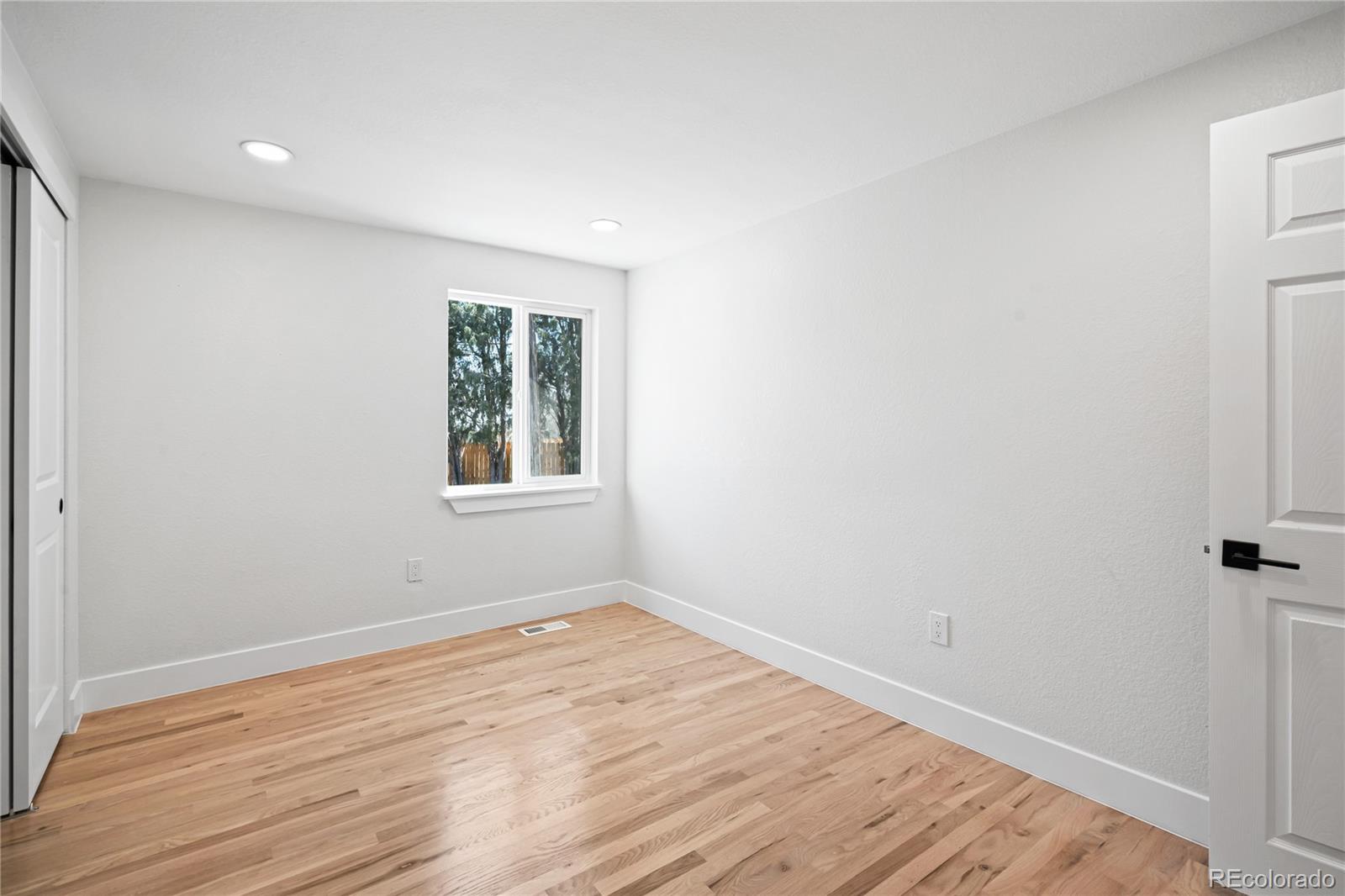 6766 Zenobia Loop Westminster, CO 80030 - Photo 29 of 50 wooden floor in an empty room with a window