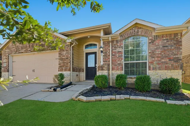 a front view of a house with a garden and plants