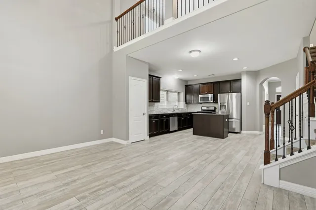 a view of a livingroom with wooden floor and a kitchen