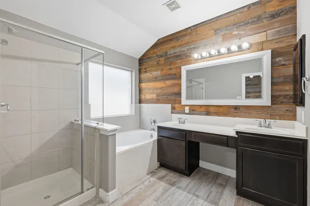 an empty room with a chandelier fan and windows