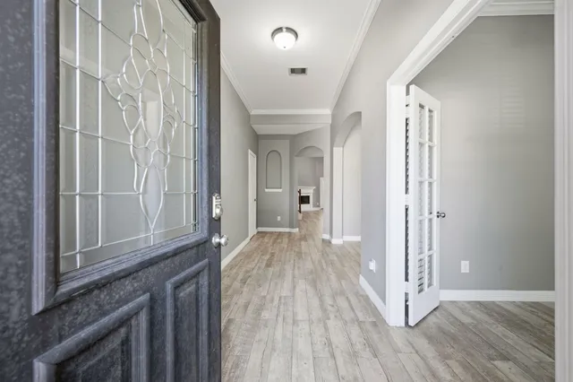 a view of a hallway with wooden floor and staircase