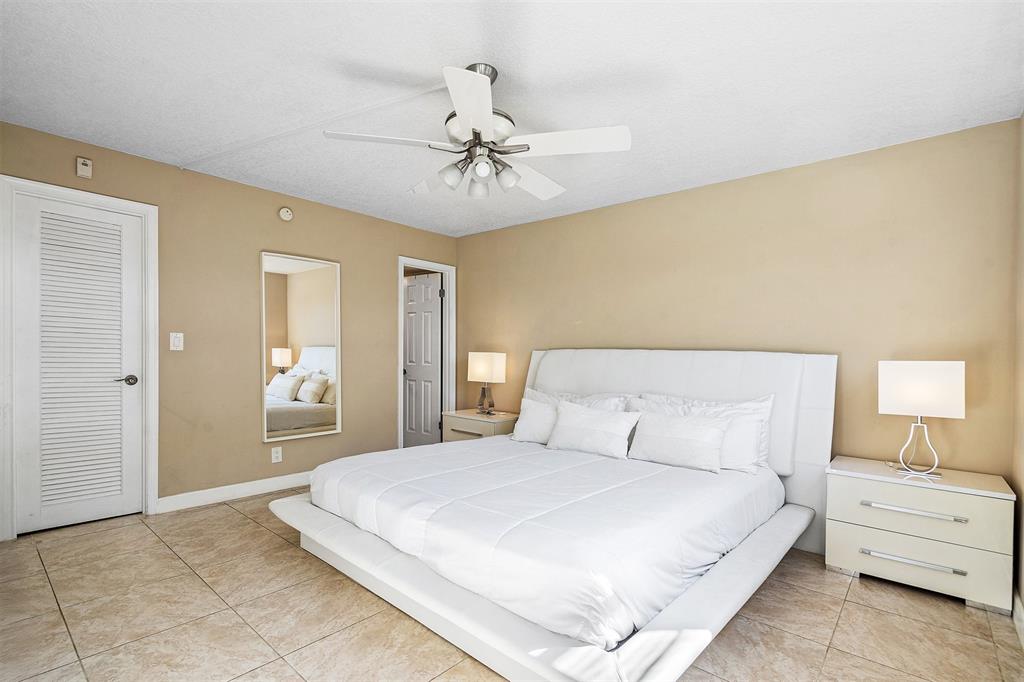 2440 DC Country Club Boulevard, Unit 111C Deerfield Beach, FL 33442 - Photo 14 of 43 a bedroom with a bed and a chandelier