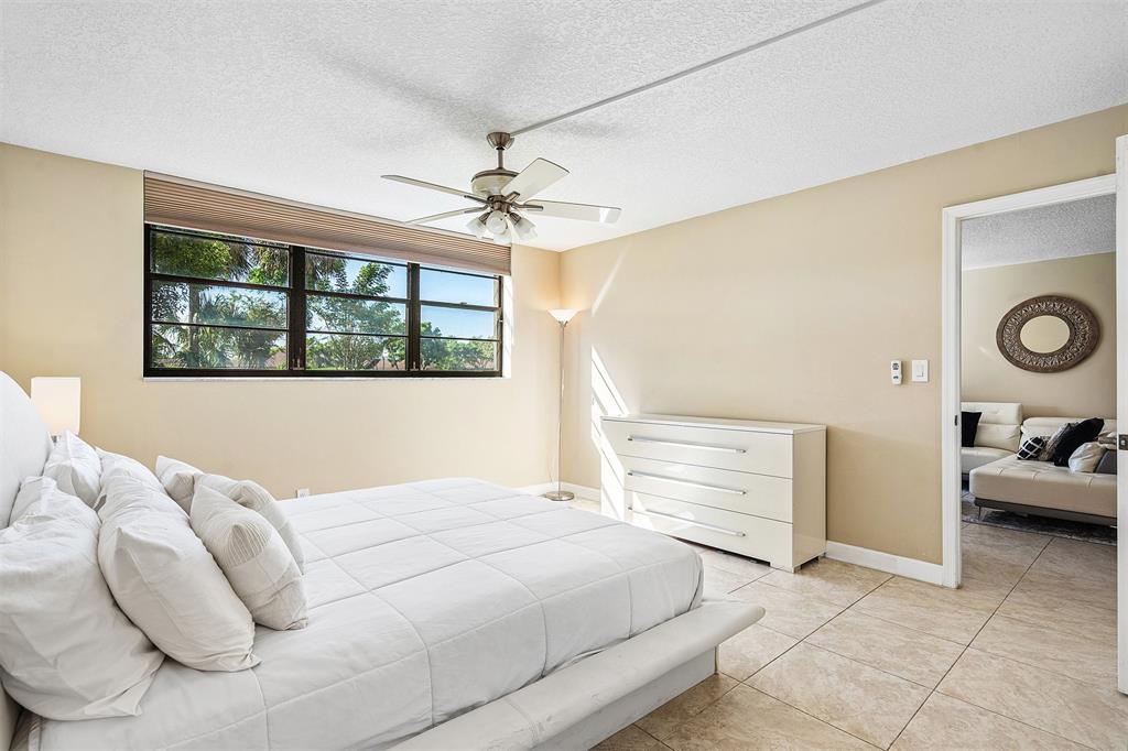 2440 DC Country Club Boulevard, Unit 111C Deerfield Beach, FL 33442 - Photo 15 of 43 a bedroom with a bed and a large window
