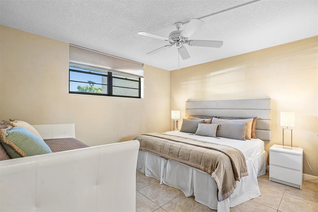 2440 DC Country Club Boulevard, Unit 111C Deerfield Beach, FL 33442 - Photo 18 of 43 a bedroom with a bed and a painting on the wall
