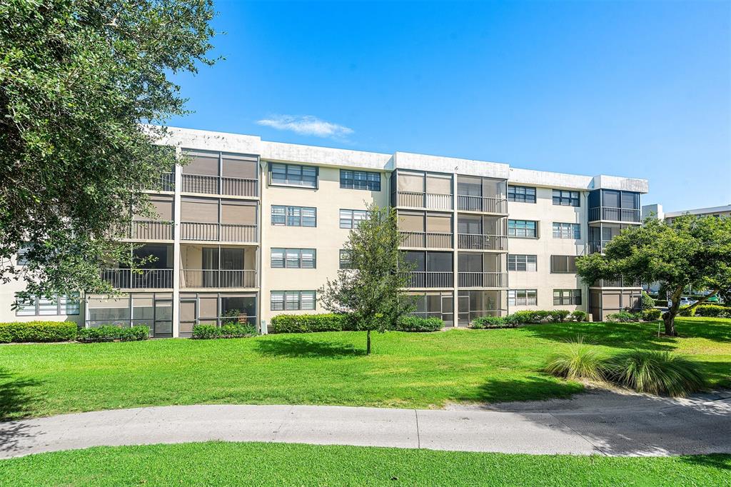 2440 DC Country Club Boulevard, Unit 111C Deerfield Beach, FL 33442 - Photo 26 of 43 a front view of a building with a yard