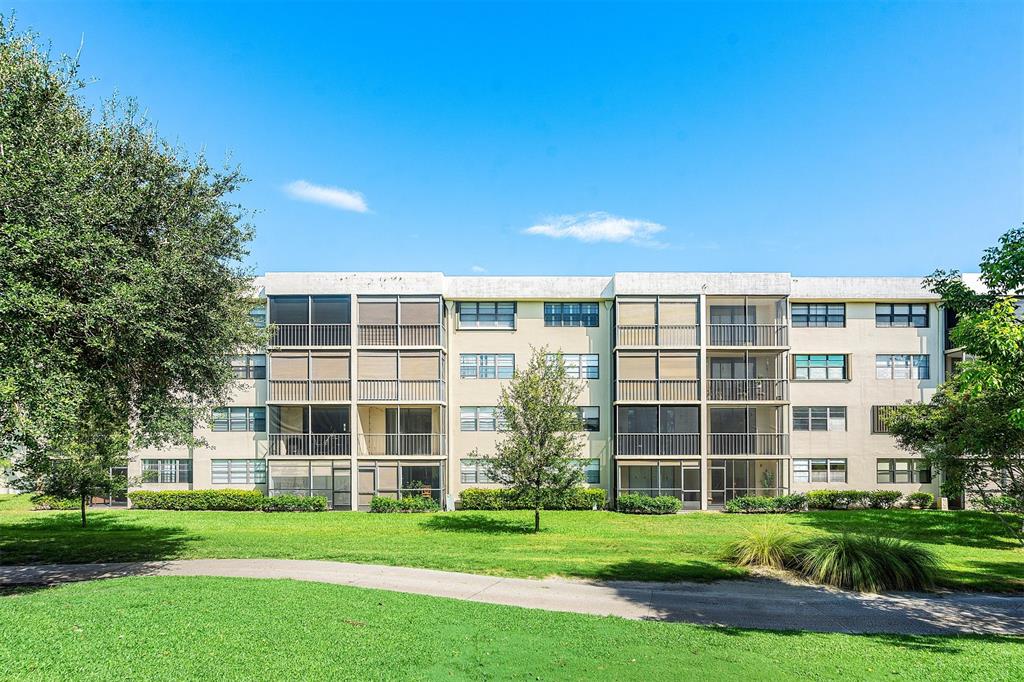 2440 DC Country Club Boulevard, Unit 111C Deerfield Beach, FL 33442 - Photo 27 of 43 a front view of a building with a garden