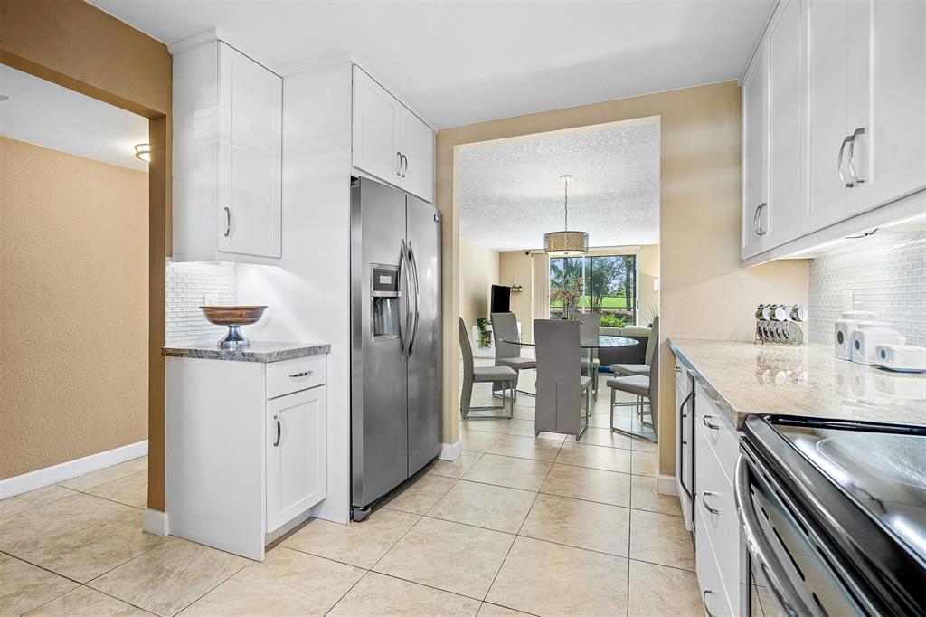 2440 DC Country Club Boulevard, Unit 111C Deerfield Beach, FL 33442 - Photo 4 of 43 a kitchen with stainless steel appliances a refrigerator sink and cabinets
