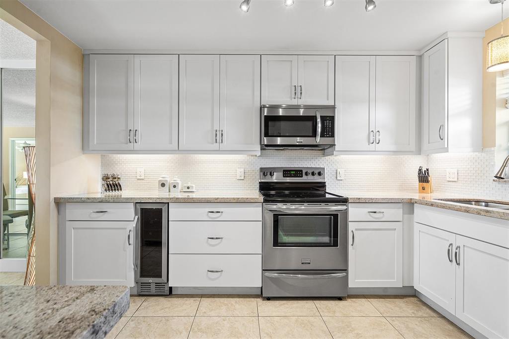2440 DC Country Club Boulevard, Unit 111C Deerfield Beach, FL 33442 - Photo 5 of 43 a kitchen with cabinets stainless steel appliances and sink