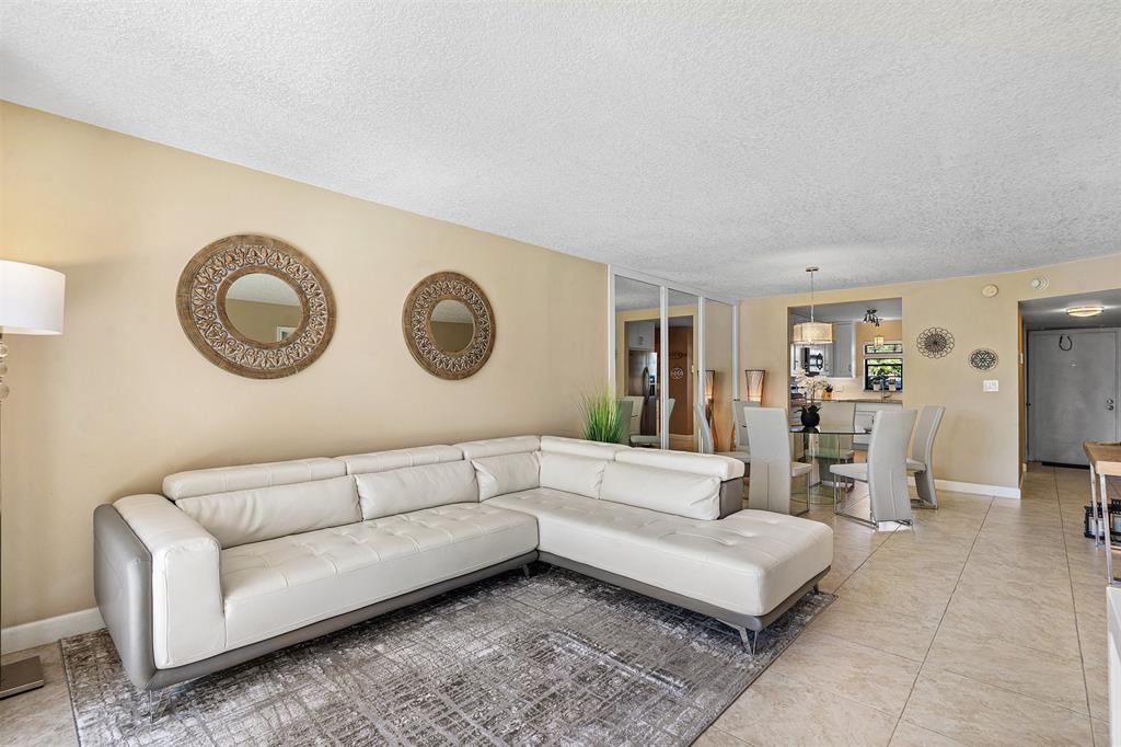 2440 DC Country Club Boulevard, Unit 111C Deerfield Beach, FL 33442 - Photo 10 of 43 a living room with furniture and a clock