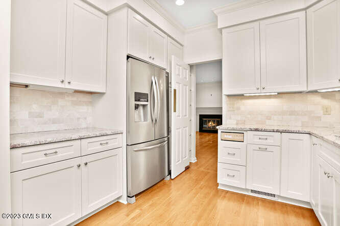 28 Home Place, Unit B1 Greenwich, CT 06830 - Photo 11 of 22 a kitchen with granite countertop white cabinets and stainless steel appliances