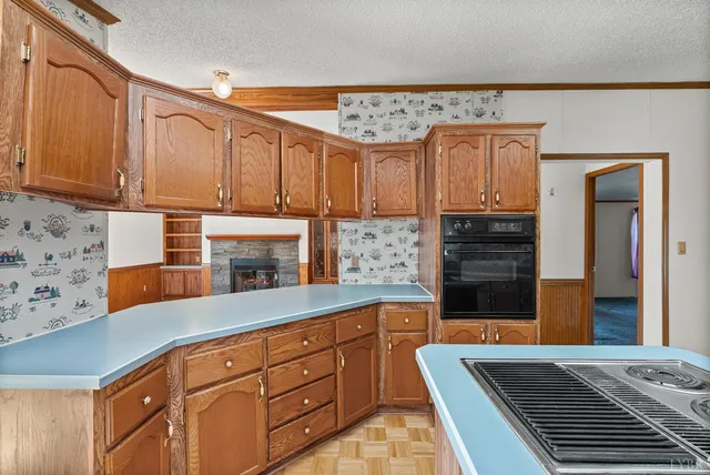 a kitchen with stainless steel appliances granite countertop a sink and wooden cabinets