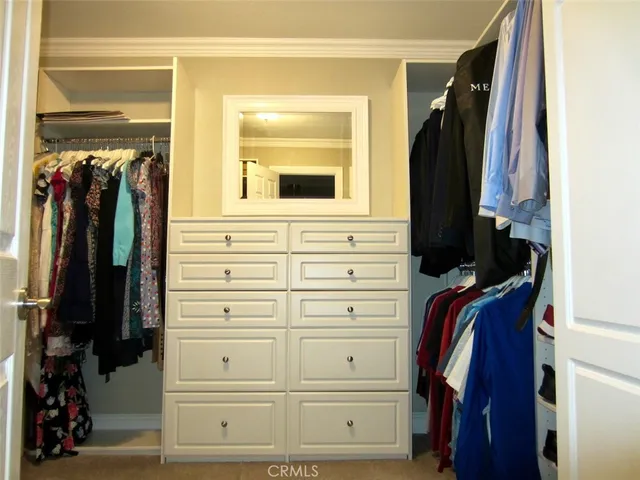 a view of walk in closet with clothes and shoes