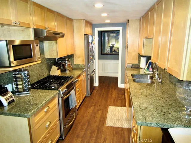 a kitchen with stainless steel appliances granite countertop a stove and a sink