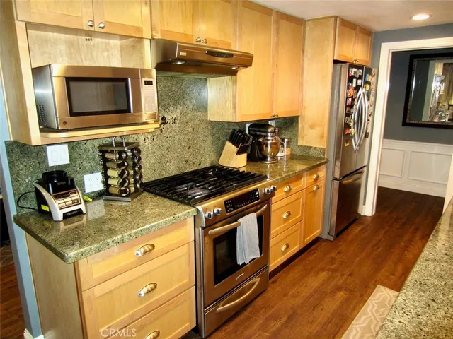 a kitchen with stainless steel appliances granite countertop a stove and a microwave