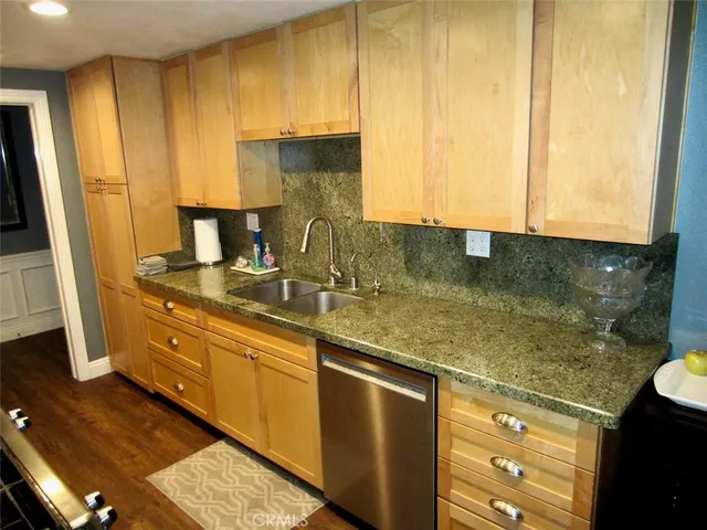 a kitchen with stainless steel appliances granite countertop a sink refrigerator and cabinets