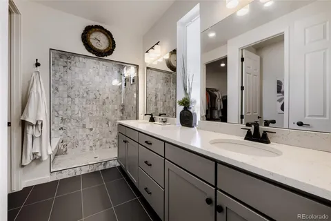 a bathroom with a double vanity sink mirror and shower