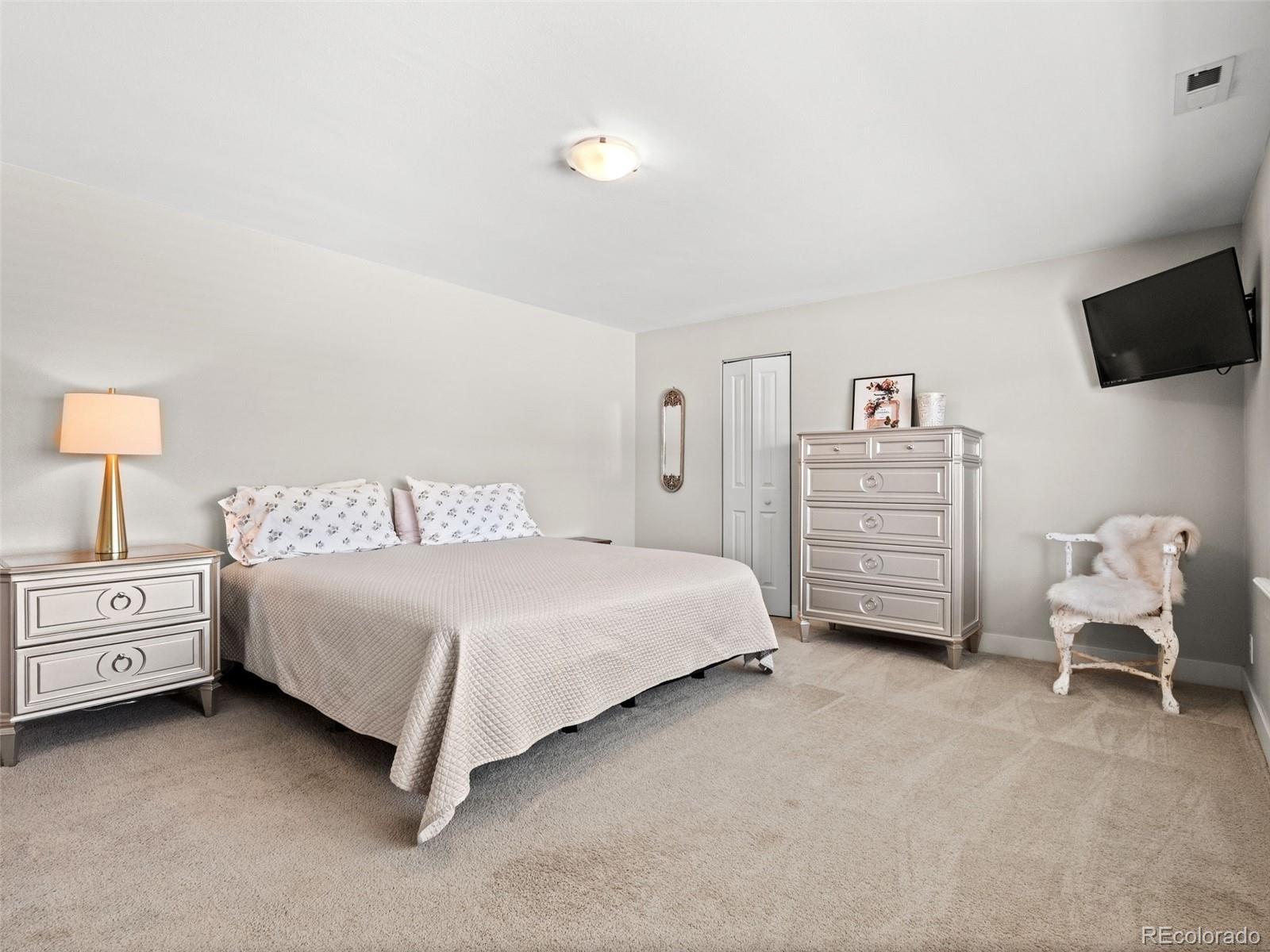 6595 West 46th Place Wheat Ridge, CO 80033 - Photo 26 of 48 a spacious bedroom with a bed and tv