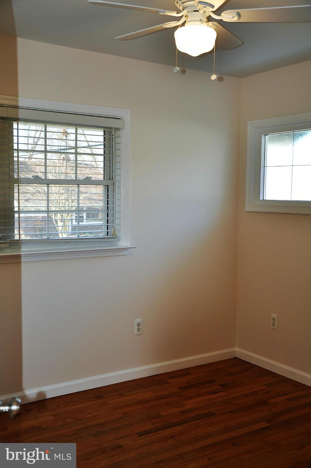 10303 Procter Street Silver Spring, MD 20901 - Photo 11 of 24 an empty room with wooden floor and windows