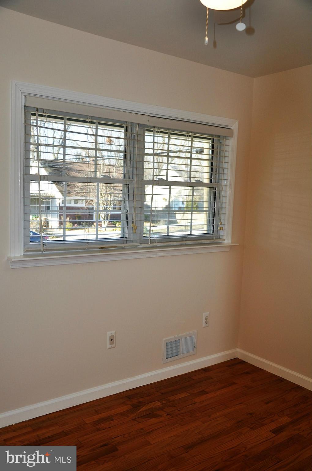 10303 Procter Street Silver Spring, MD 20901 - Photo 13 of 24 a view of an empty room with wooden floor and a window