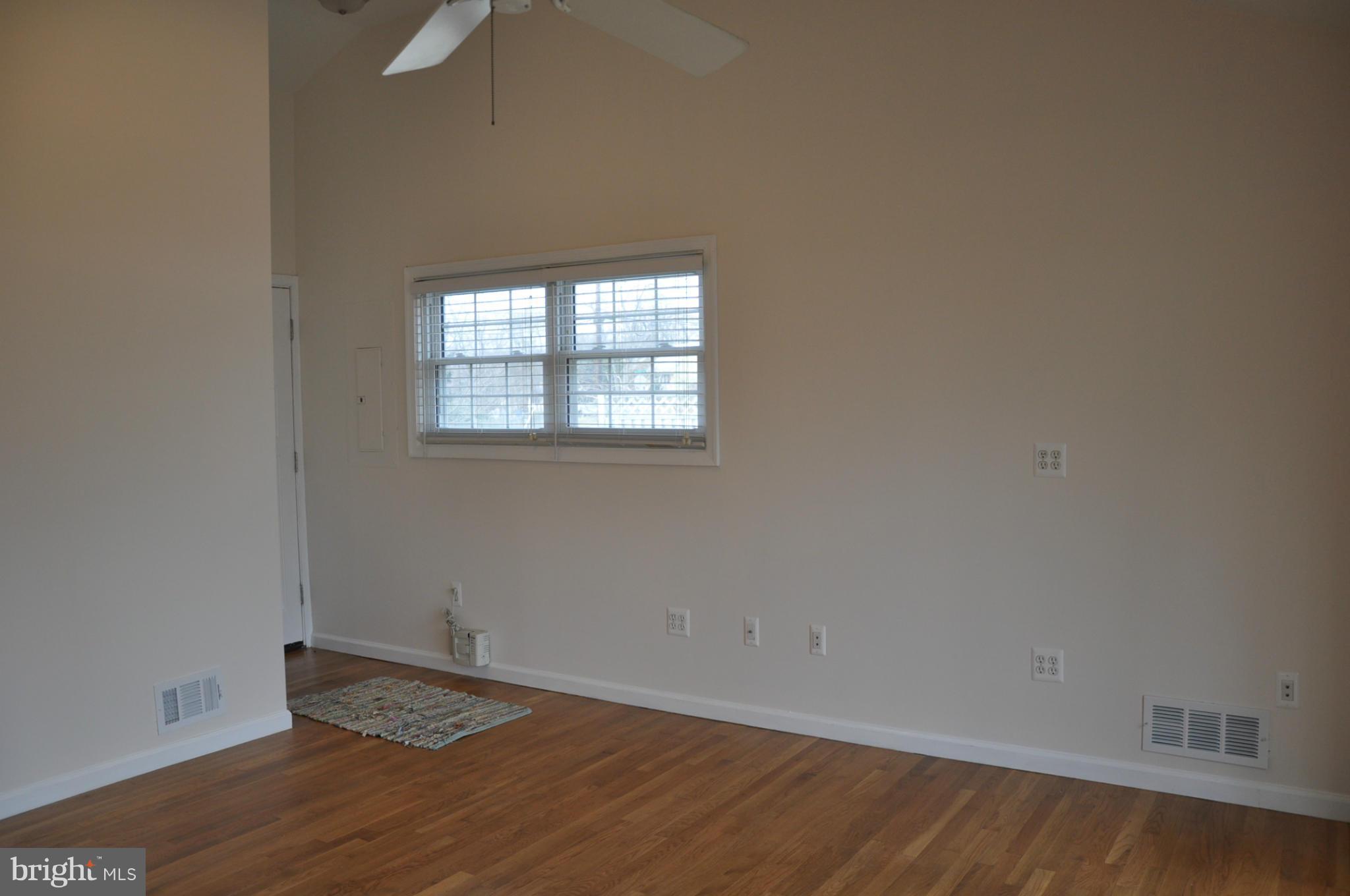 10303 Procter Street Silver Spring, MD 20901 - Photo 5 of 24 an empty room with wooden floor and windows