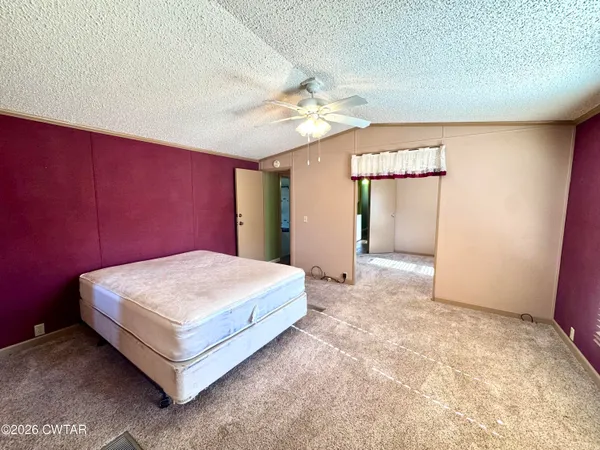 a spacious bedroom with a bed and a dresser