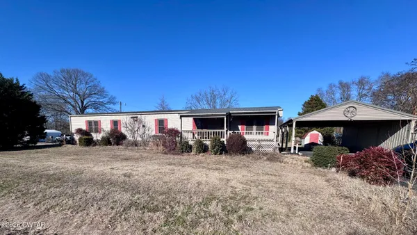 a view of a house with a yard and sitting area