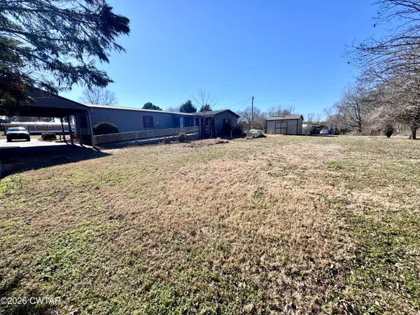 a view of a yard covered with snow in front of house