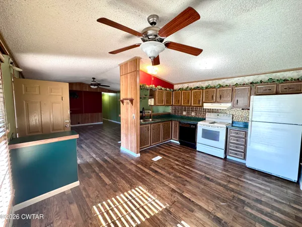 a kitchen with stainless steel appliances kitchen island granite countertop a refrigerator and a stove