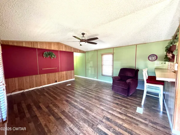 a view of a livingroom with furniture a ceiling fan and wooden floor